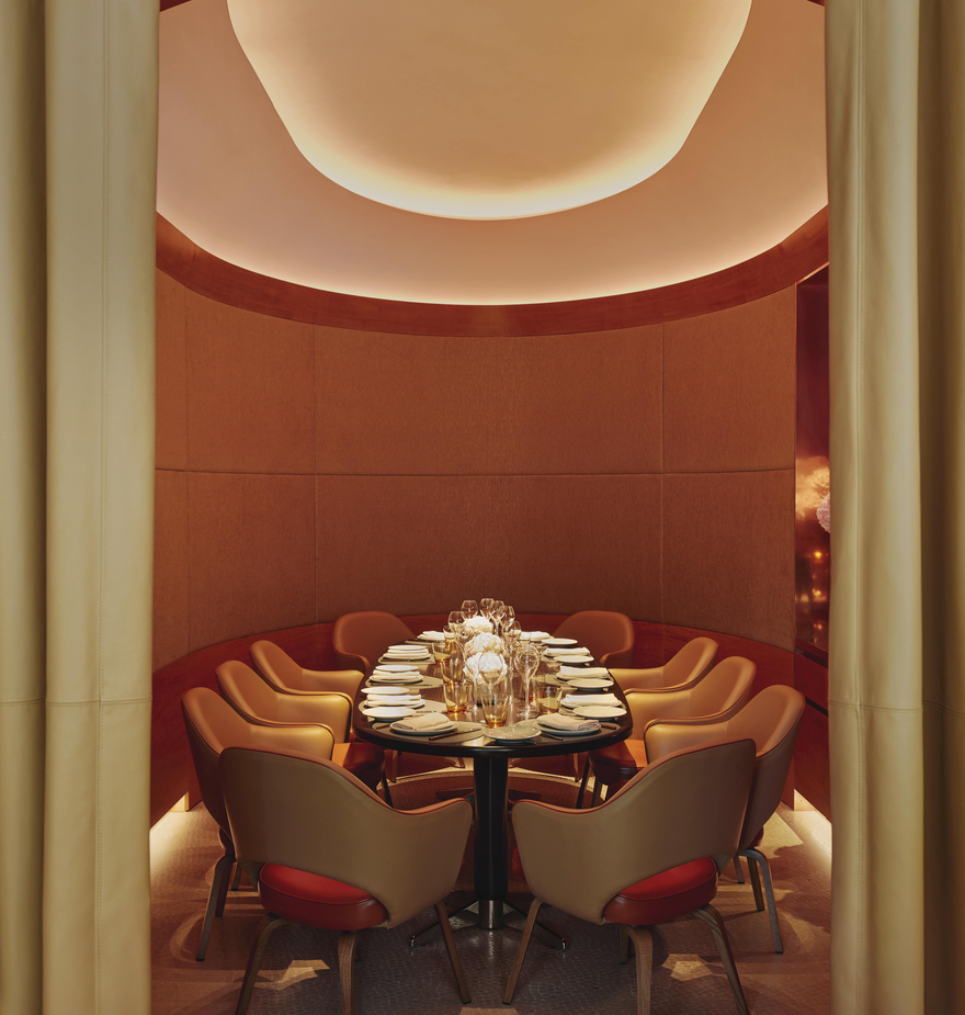 Intimate private dining room with elegant seating, soft lighting, and a warmly lit ceiling, creating a cozy, sophisticated ambiance.