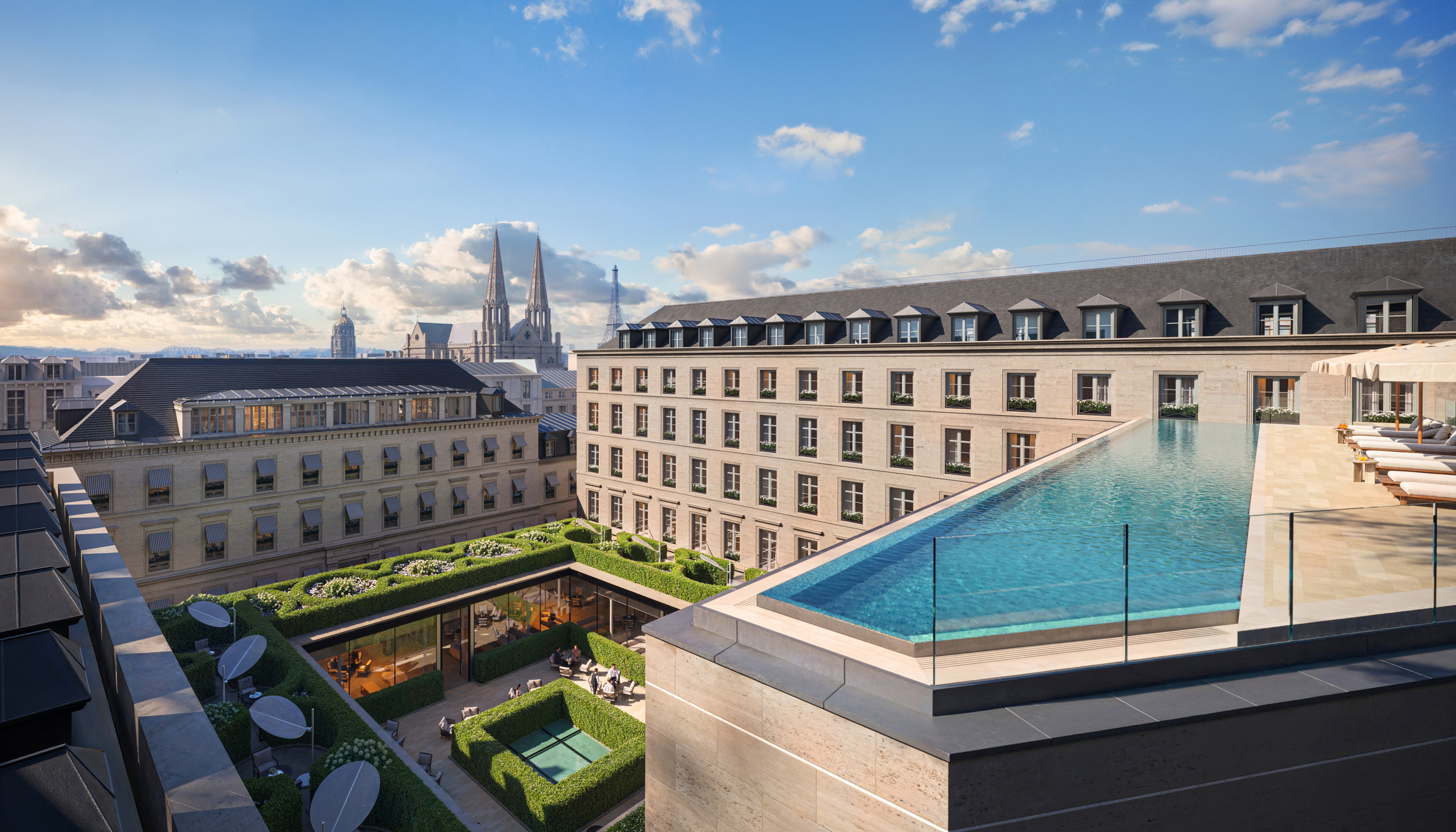 Rooftop infinity pool with sun loungers overlooking Paris rooftops and landmarks including the Eiffel Tower in the background.