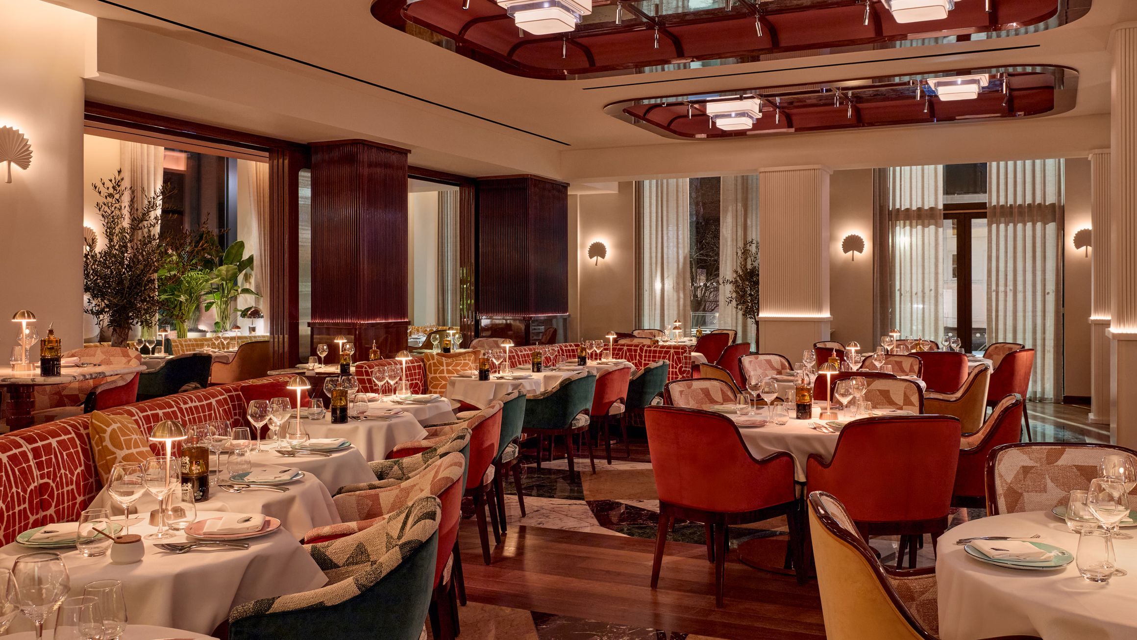Elegant restaurant interior with rich tones, plush seating, soft lighting, and art deco-inspired details throughout the dining space.