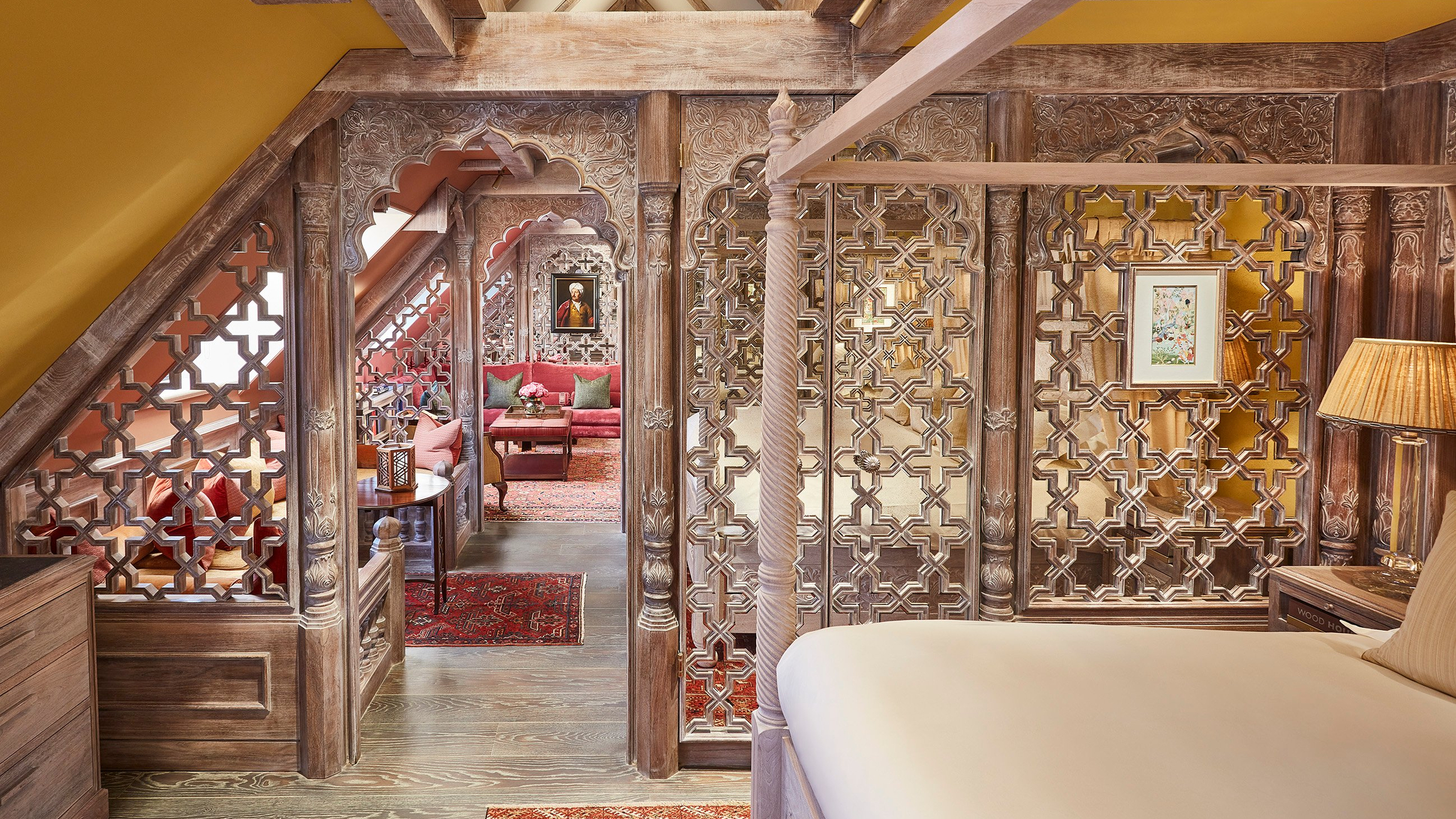 Ornate wooden latticework and rich textiles create a regal, intimate ambiance in this intricately designed luxury suite.