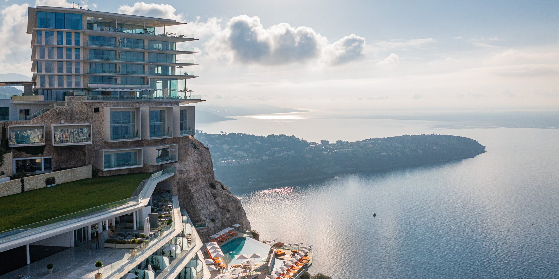 A breathtaking clifftop hotel overlooking the Mediterranean, featuring modern architecture, infinity pools, and panoramic views of the coastline.