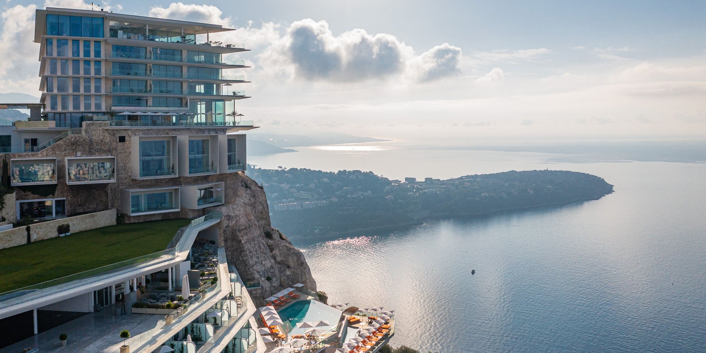 A breathtaking clifftop hotel overlooking the Mediterranean, featuring modern architecture, infinity pools, and panoramic views of the coastline.
