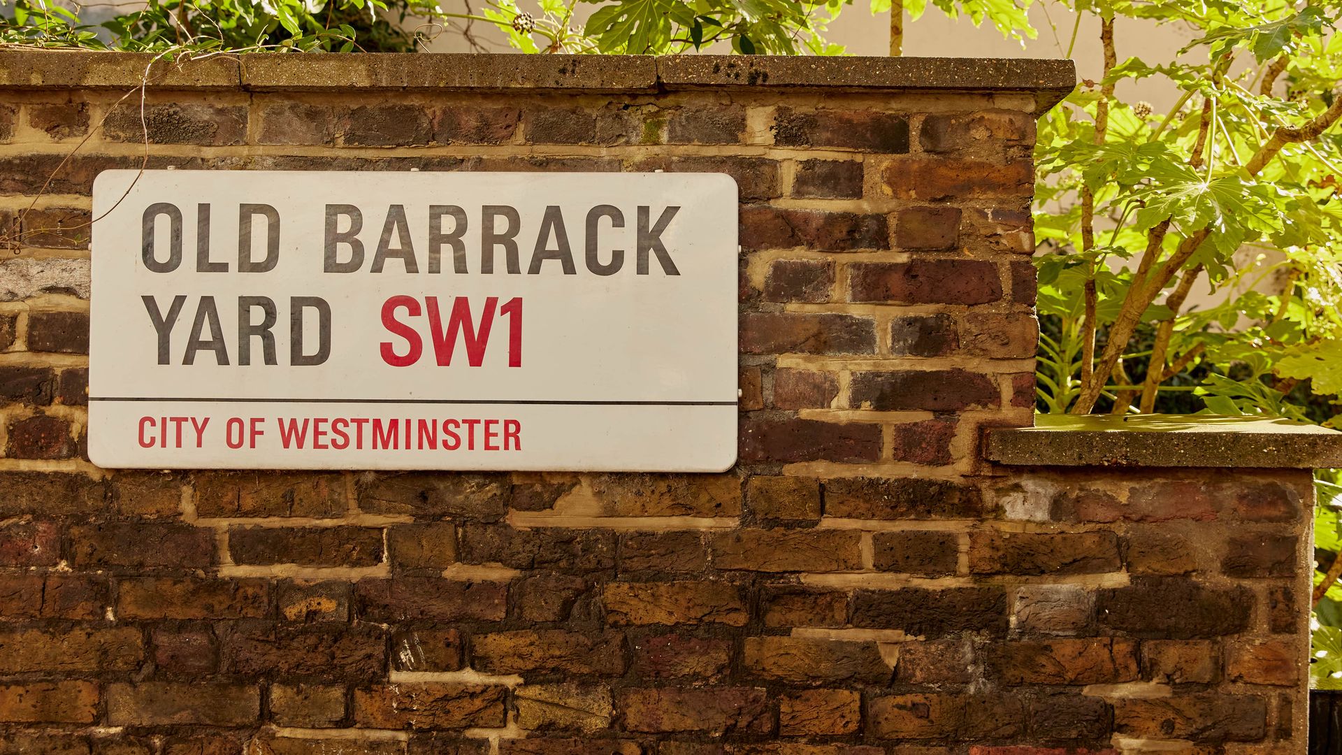 Old Barrack Yard SW1 street sign on a brick wall in Belgravia, London.