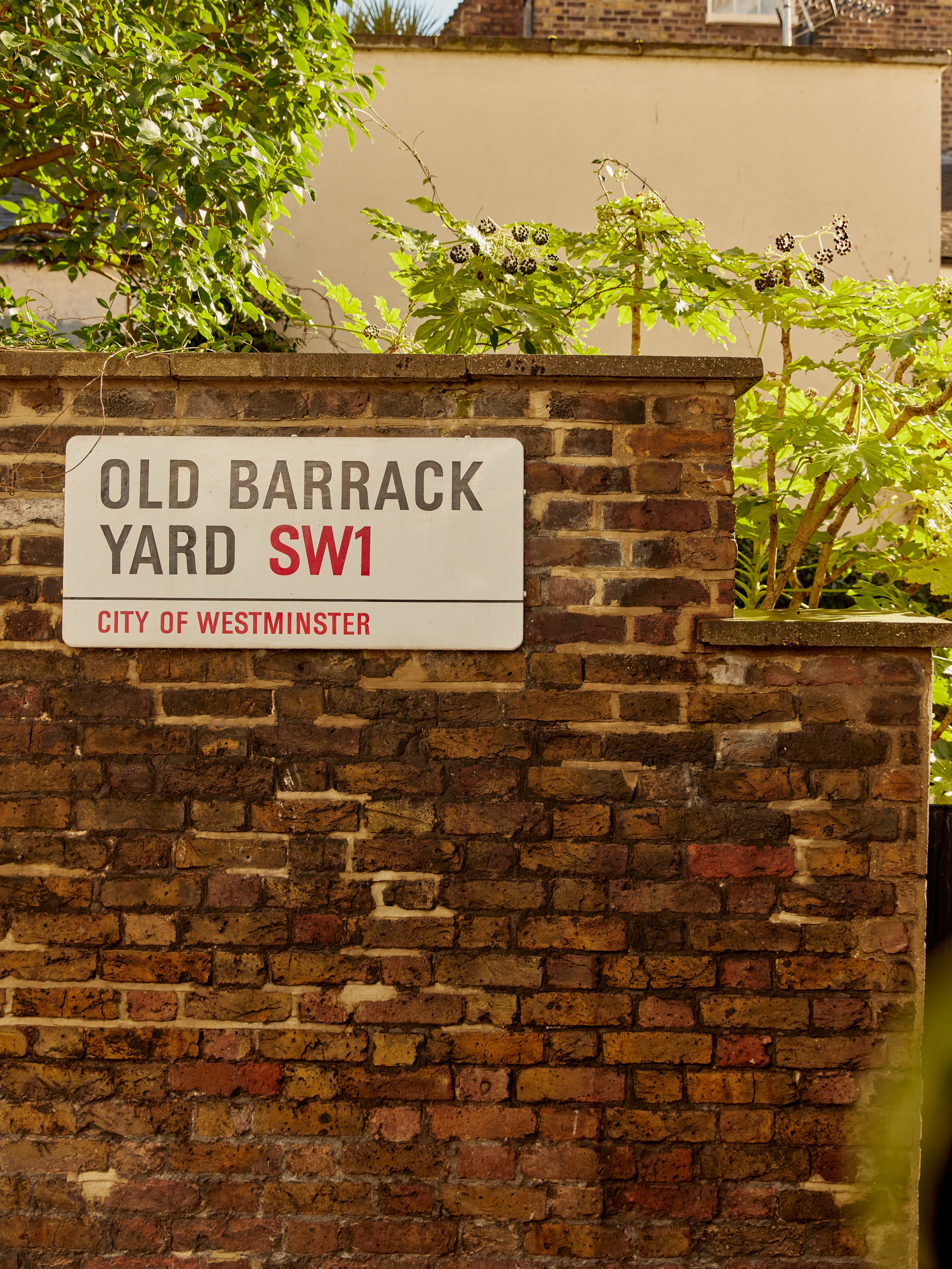 Old Barrack Yard SW1 street sign on a brick wall in Belgravia, London.