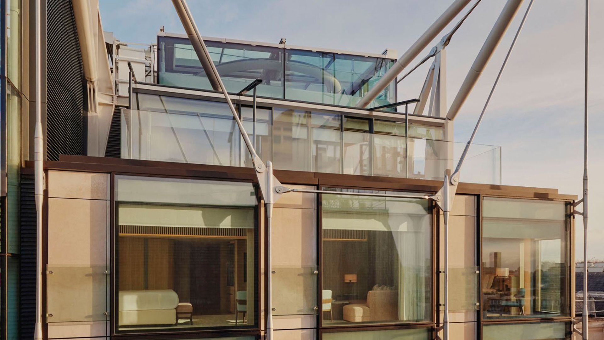 The Emory's modern facade showcases floor-to-ceiling windows, reflecting bespoke interiors and architectural harmony under its striking steel frame.