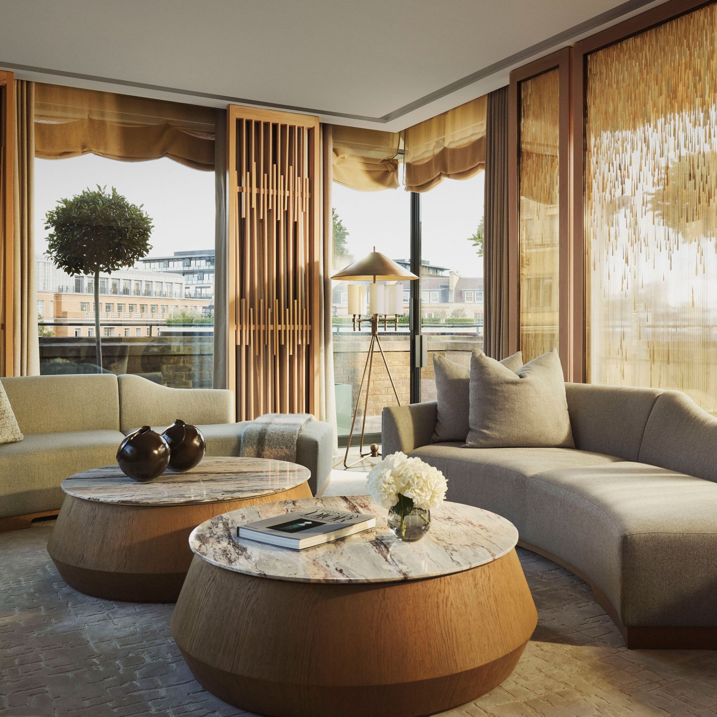 Contemporary penthouse lounge with curved sofas, marble tables, and golden-accented screens, overlooking a private terrace with topiary trees and city views.