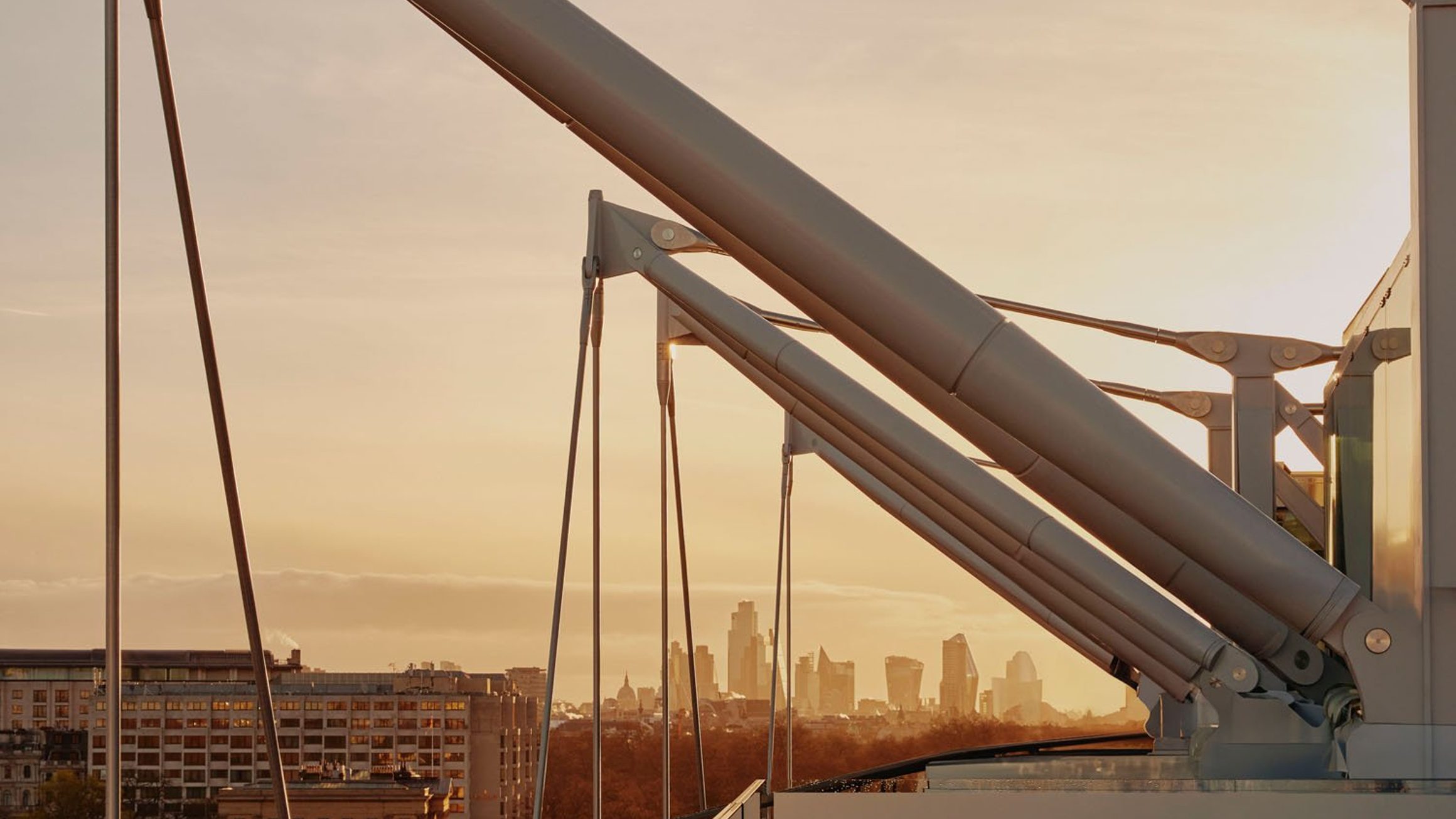 Sunlit urban skyline framed by modern architectural details, blending precision engineering with a warm cityscape glow.