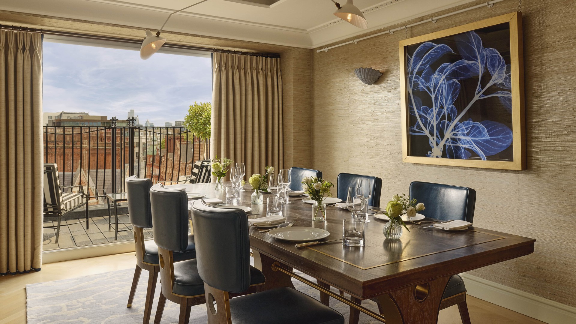 Elegant dining room with city views, a large wooden table, and modern wall art.