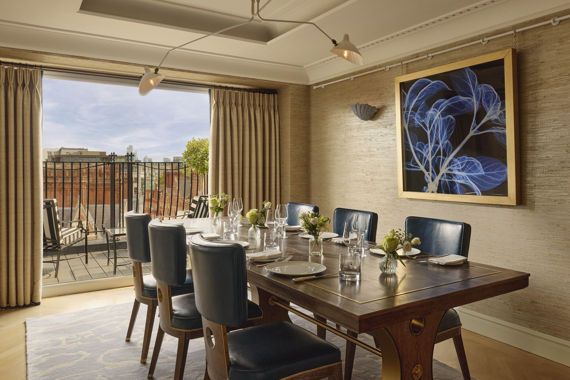 Elegant dining room with city views, a large wooden table, and modern wall art.