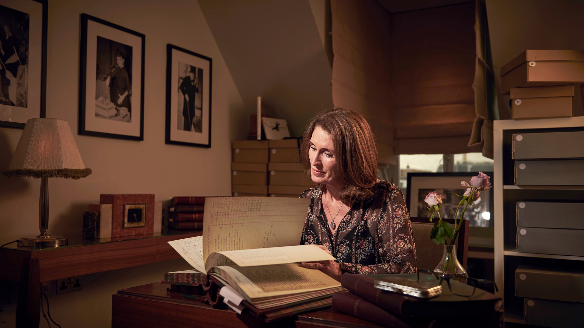 An archivist engrossed in historic documents, surrounded by books, framed photos, and a serene, softly lit study.