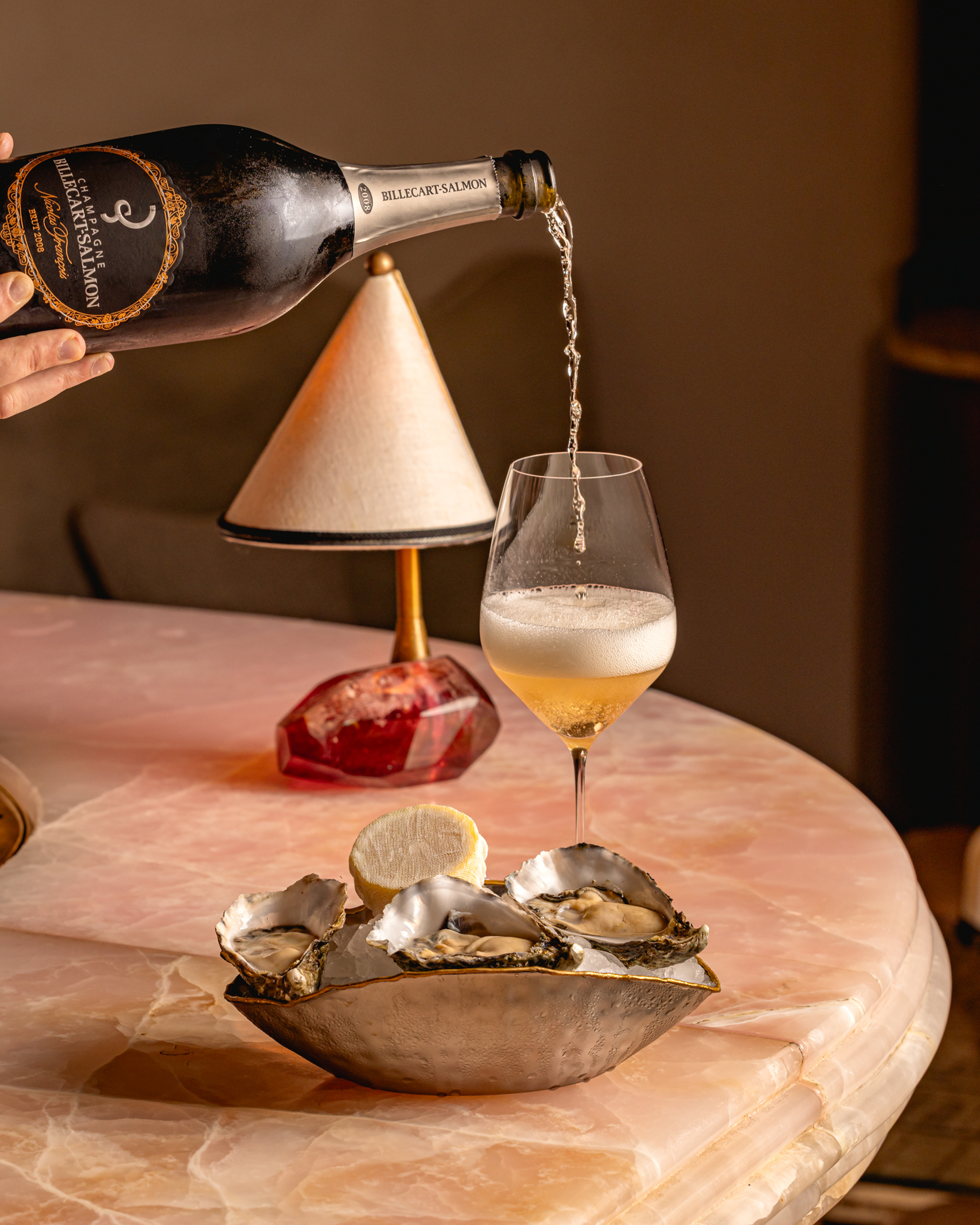 Chilled oysters served with a glass of champagne being poured, exuding effortless indulgence and sophistication.