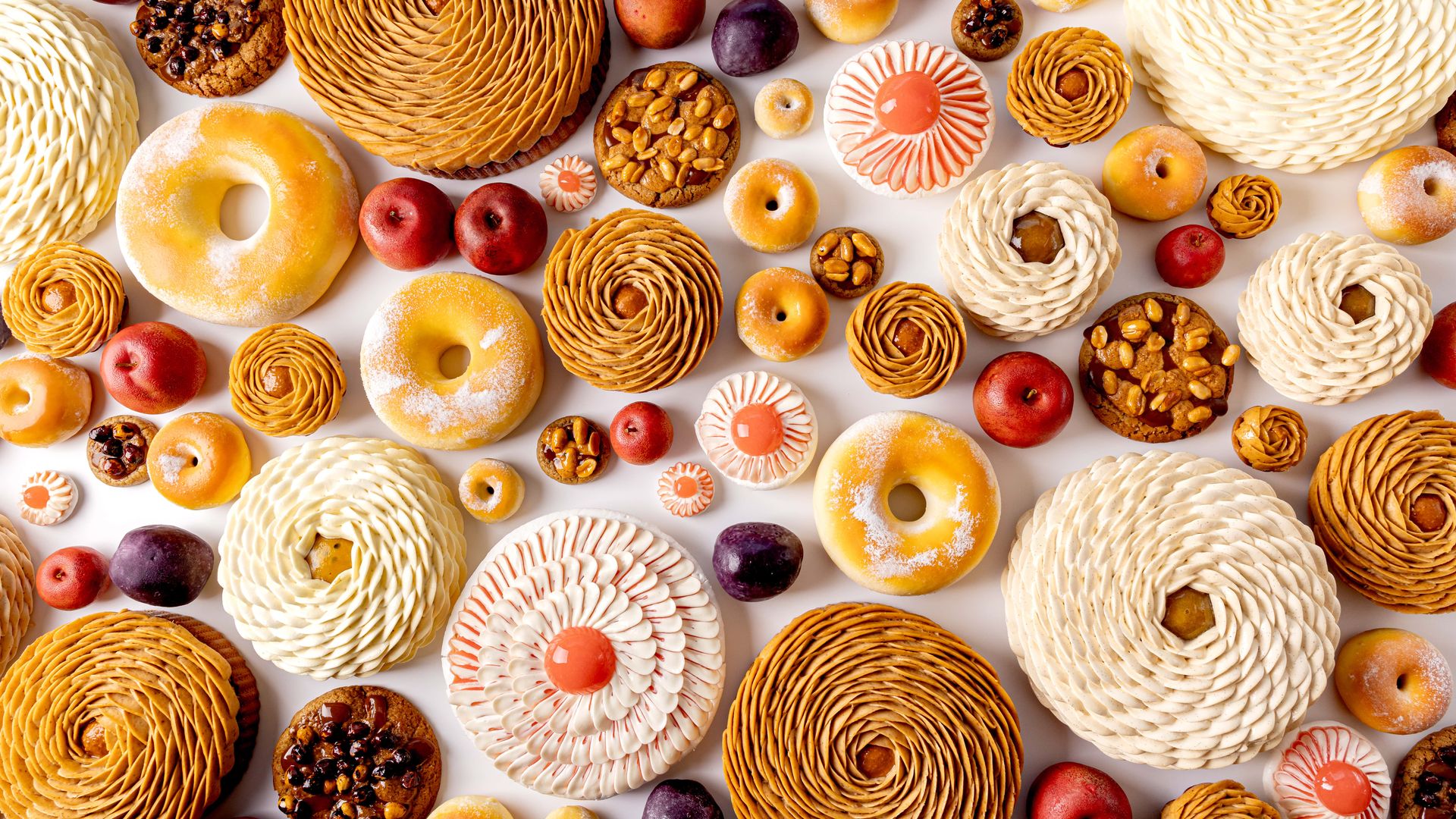 Assorted pastries and desserts arranged artfully in a vibrant overhead display.