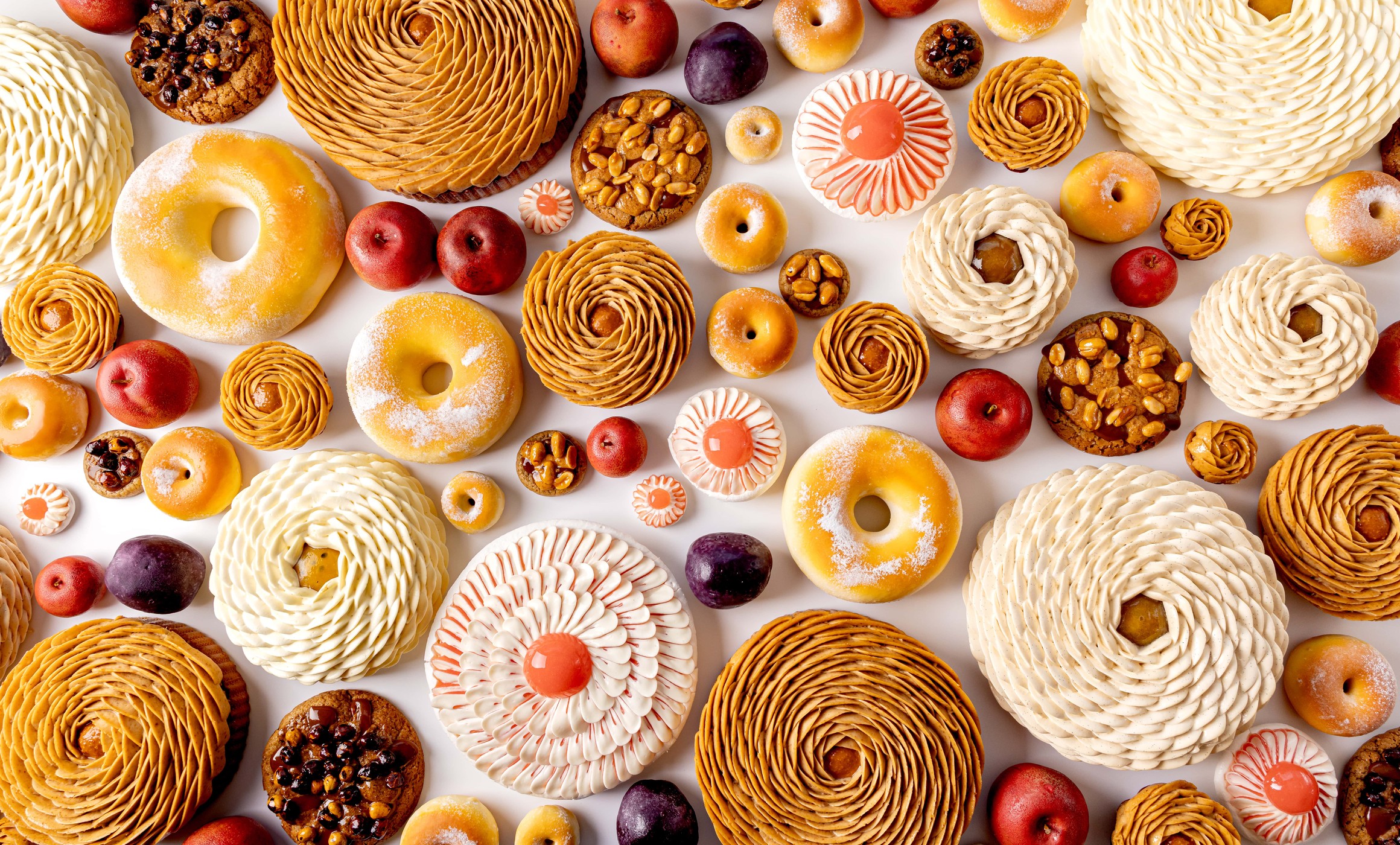 Assorted pastries and desserts arranged artfully in a vibrant overhead display.